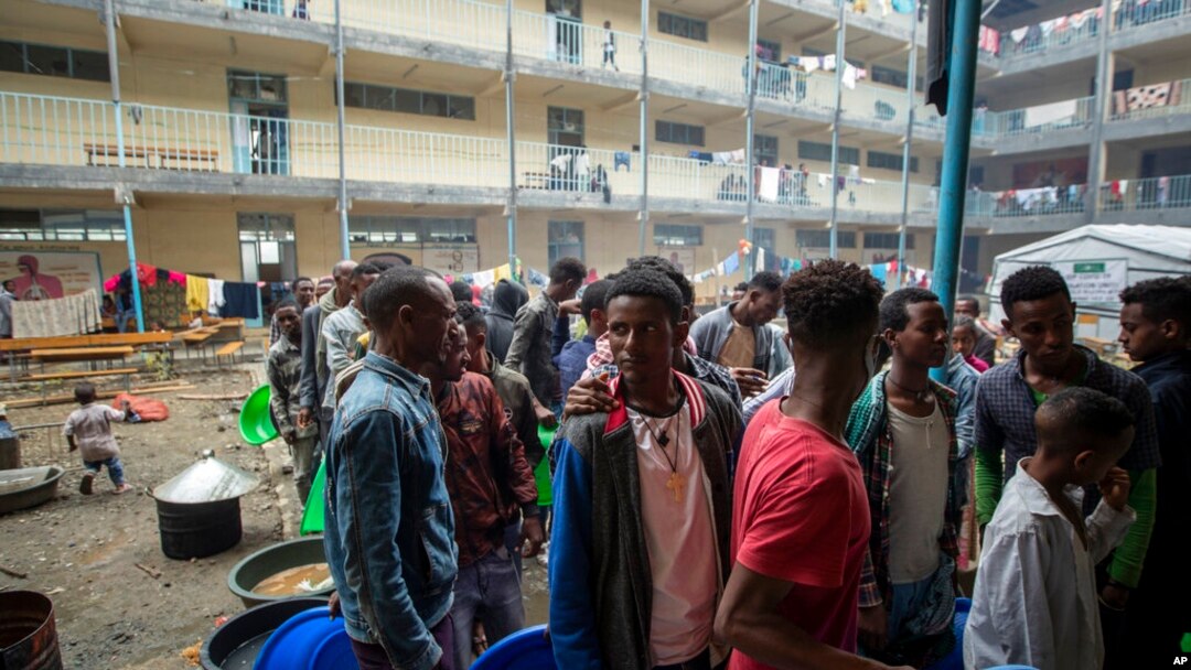 FILE - Displaced Tigrayans queue to receive food at the Hadnet General Secondary School, which has become a makeshift home to thousands displaced by the conflict, in Mekele, in the Tigray region of northern Ethiopia, May 5, 2021. 