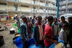 FILE - Displaced Tigrayans queue to receive food at the Hadnet General Secondary School, which has become a makeshift home to thousands displaced by the conflict, in Mekelle, in the Tigray region of northern Ethiopia, May 5, 2021.