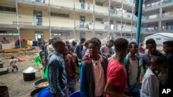 FILE - Displaced Tigrayans queue to receive food at the Hadnet General Secondary School, which has become a makeshift home to thousands displaced by the conflict, in Mekele, in the Tigray region of northern Ethiopia, May 5, 2021. 