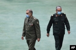 FILE - Gen. Mohammad Reza Ashtiani, left, and Reza Talaei Nik, deputy defense minister, walk in the parliament in Tehran, Iran, Aug. 22, 2021