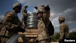 Soldados de EE.UU. instalan rollos de alambre de púas en la frontera con México, en Hidalgo, Texas. Noviembre 8 de 2018.