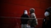 Women wearing face masks and face shields talk on a street, as COVID-19 outbreaks continue in Shanghai, China, Dec. 12, 2022. 