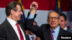 FILE - Former New York Governor Mario Cuomo celebrates with his son, Andrew, after the younger Cuomo won re-election as governor of the state, Nov. 4, 2014. 
