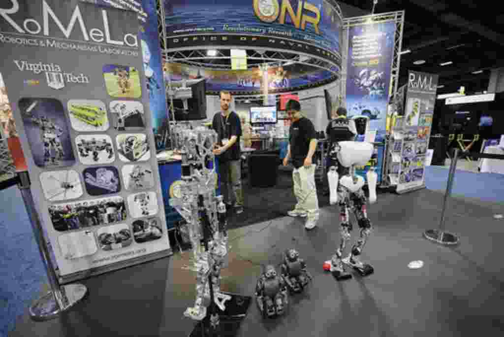 Michael Hopkins, a la izquierda, y Bryce Lee, estudiantes de posgrado en el Tecnológico de Virginia, trabajan en el Laboratorio de Robótica y Mecanismos en una demostracón de robots autónomos, en la Oficina de Investigación Naval de la exposición durante 