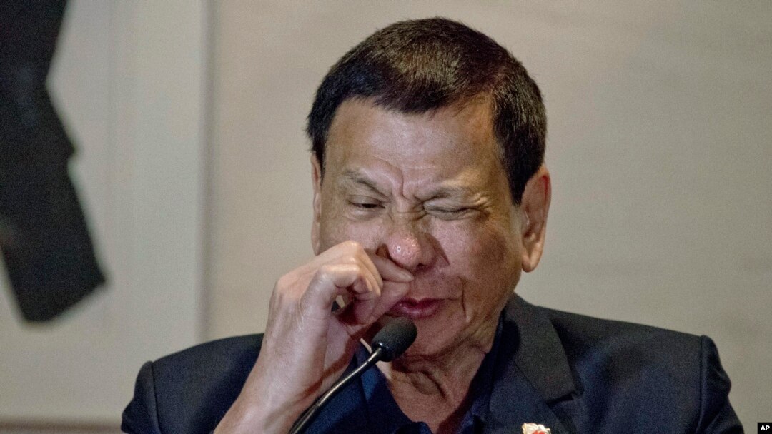 Presiden Filipina Rodrigo Duterte mendemonstrasikan bagaimana pecandu narkoba mengirup zat tersebut dalam konferensi pers di Beijing, Oktober 2016. (AP/Ng Han Guan)