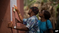 FILE: People check for their names on the voters registration list during the presidential elections in Agulu, Nigeria, Saturday, Feb. 25, 2023. Voters in Africa's most populous nation are heading to the polls Saturday March 18 to choose state governors and lawmakers.