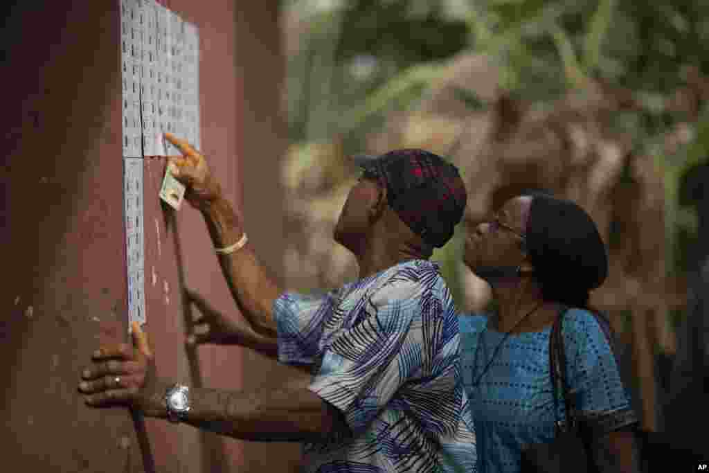 People check for their names on the voters registration list during the presidential elections in Agulu, Nigeria, Saturday, Feb. 25, 2023.&nbsp;