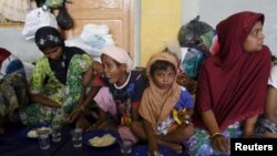 Migran yang diyakini berasal dari Rohingya mendapat sarapan setelah diselamatkan dari kapal di Lhoksukon, Aceh, Selasa (12/5).me