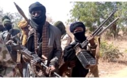 Members of a "bandit" gang pose with weapons at their forest hideout in northwestern Zamfara state, Nigeria, Feb. 22, 2021. (Sani Malumfashi/VOA)