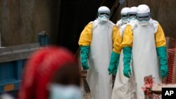 FILE - Health workers dressed in protective gear begin their shift at an Ebola treatment center in Beni, Democratic Republic of Congo, July 16, 2019.