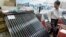 FILE - A solar water heater, left, and a solar panel are seen at Entech Hanoi, an international trade fair on energy efficiency and the environment, at the Giang Vo Exhibition Center in Hanoi, Vietnam.
