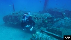 A diver explores the wreckage of an American bombardier fighter plane from the Second World War, the Lockheed P-38G Lightning, at 38 meters of depth, on August 12, 2018, off the coast of La Ciotat, southern France.