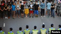 Barisan polisi berhadapan dengan para demonstran pro-Demokrasi dekat gedung pemerintah pusat di Hong Kong (13/10).