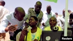 FILE - Officials from the Independent Electoral and Boundaries Commission (IEBC) assist residents to confirm their data during launch of 2017 general elections voter registration exercise within Kibera slums in Nairobi, January 16, 2017.