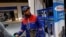 FILE - A gas station attendant pumps fuel into a customer's car at a gas station in Tunis, Tunisia, March 31, 2018.