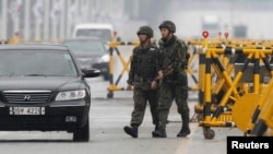 South Korean soldiers patrol as vehicles returning from North Korea's inter-Korean Kaesong Industrial Complex back to South Korea arrive at a checkpoint on the Grand Unification Bridge, which leads to the demilitarized zone separating North Korea from Sou