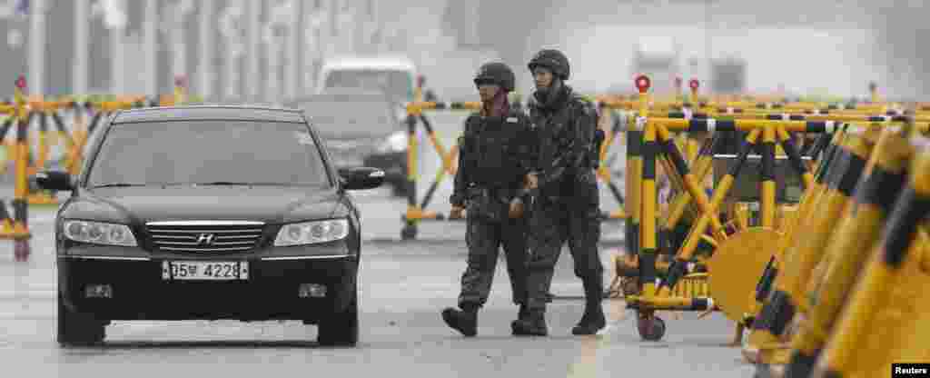 Des soldats sud-cor&eacute;ens en patrouille alors que des v&eacute;hicules rentrant de la zone industrielle de Kaesong en Cor&eacute;e du Nord franchissent le Grand Pont de l&#39;Unification conduisant &agrave; la zone d&eacute;militaris&eacute;e. 