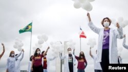 Des infirmières lors d'une manifestation demandant des vaccins contre la COVID-19, à Brasilia, au Brésil, le 7 avril 2021.
