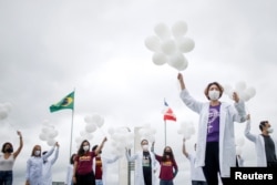 Nurses hold balloons during a protest asking for COVID-19 vaccines, in Brasilia, Brazil, April 7, 2021.