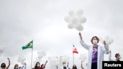 Nurses hold balloons during a protest asking for COVID-19 vaccines, in Brasilia, Brazil, April 7, 2021.