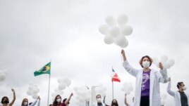 Nurses hold balloons during a protest asking for COVID-19 vaccines, in Brasilia, Brazil, April 7, 2021.