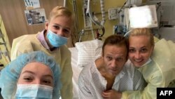 TOPSHOT - This handout picture posted on September 15, 2020 on the Instagram account of @navalny shows Russian opposition leader Alexei Navalny posing for a selfie picture with his family at Berlin's Charite hospital. (Photo by Handout / Instagram…