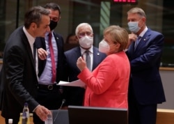 German Chancellor Angela Merkel, 2nd right, speaks with, from left, Greek PM Kyriakos Mitsotakis, Spain's PM Pedro Sanchez, Portugal's PM Antonio Costa and Romania's President Klaus Werner Ioannis at an EU summit in Brussels, July 21, 2020.