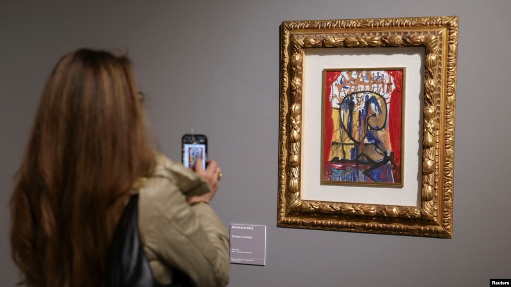 Una mujer toma fotografías de una ilustración para Romeo y Julieta de Salvador Dalí en la exposición "SalvArti, de las confiscaciones a las colecciones públicas", en Milán, Italia, el 3 de diciembre de 2024. REUTERS