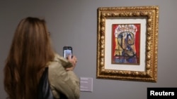 Una mujer toma fotografías de una ilustración para Romeo y Julieta de Salvador Dalí en la exposición "SalvArti, de las confiscaciones a las colecciones públicas", en Milán, Italia, el 3 de diciembre de 2024. REUTERS