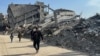 Palestinians walk past the rubble of destroyed houses during a ceasefire between Israel and Hamas in Khan Younis in the southern Gaza Strip, March 6, 2025. 