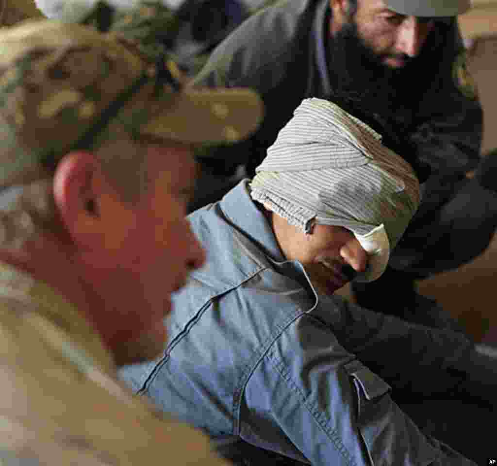 2011年10月6日，一名“北约阿富汗培训使命”的美军顾问在阿富汗东部的库纳尔省向阿富汗警察展示如何包扎伤员的头部。