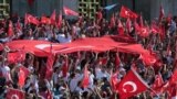 Turkish citizens wave their national flags as they protest against the military coup outside Turkey's parliament near the Turkish military headquarters in Ankara, Turkey, July 16, 2016. 