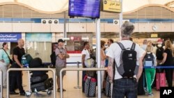 A British tourist looks at a flight information panel at the airport of Sharm el-Sheikh, Egypt, Nov. 7, 2015.