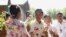 A woman presents flowers to former Myanmar ruling Union Solidarity and Development Party (USDP) chief Shwe Mann, as he campaigns at a village near his hometown Kanyuntkwin, Myanmar, Nov. 4, 2015. Myanmar will hold its historic general election on November