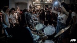 Protesters give a concert at the "Occupy" movement campsite area outside the HSBC bank headquarters in Hong Kong on August 27, 2012.