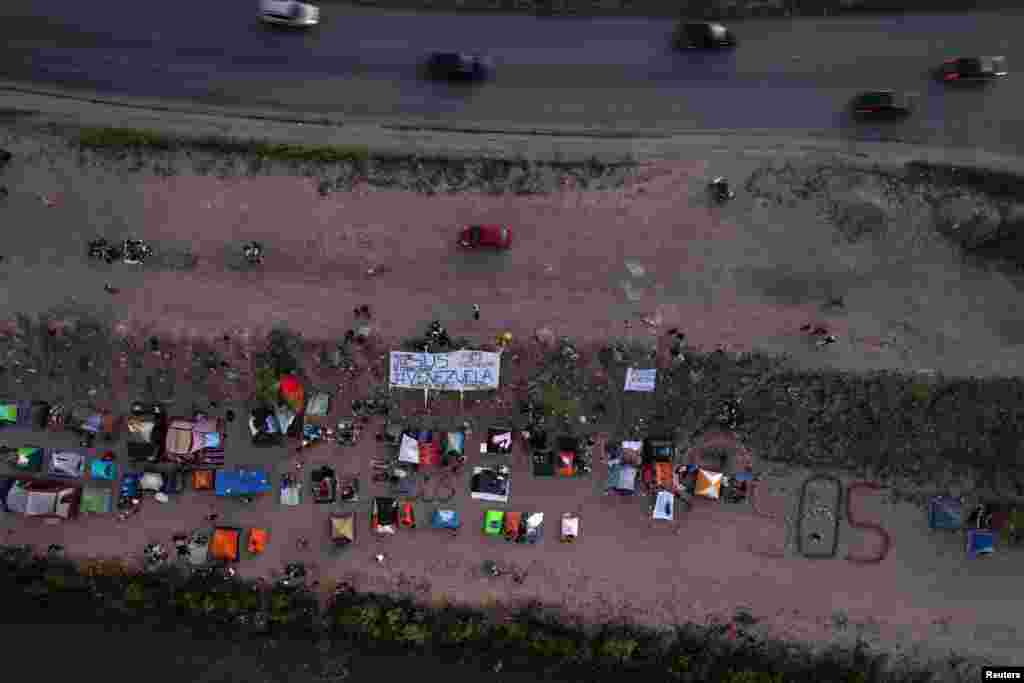 Migrantes venezolanos, algunos expulsados de EEUU a México bajo el Título 42 y otros que aún no han cruzado tras las nuevas políticas migratorias, hacen fila para recibir alimentos a orillas del Río Bravo, en Ciudad Juárez, México, el 26 de octubre de 2022. REUTERS/José Luis González&nbsp;&nbsp;