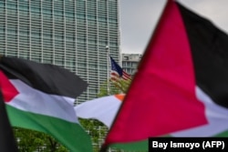 Bendera Palestina dikibarkan oleh para demonstran yang ikut serta dalam protes terhadap Israel di depan kedutaan besar AS di Jakarta pada 20 Mei 2021, di tengah konflik yang sedang berlangsung antara Israel dan Wilayah Palestina. (Foto: BAY ISMOYO/AFP)