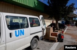 Pekerja UNRWA mengangkut kotak bantuan kemanusiaan di kompleks kantor lapangan UNRWA di Tepi Barat, di lingkungan Sheikh Jarrah di Yerusalem Timur. (Foto: Reuters)