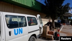 联合国近东巴勒斯坦难民救济和工程处(UNRWA)的工作人员2024年1月30日在约旦河西岸装运人道救援物资。（路透社）