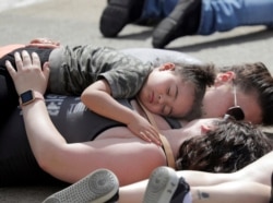 Protesters lie on the ground during a Black Lives Matter rally May 31, 2020, in Oshkosh, Wis.