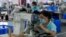Công nhân tại một nhà máy sản xuất thiết bị thể thao trượt tuyết tại Zhangjiakou ở tây bắc Trung Quốc. Động lực kinh tế suy yếu của Trung Quốc đang ảnh hưởng đến hoạt động sản xuất của các nhà máy ở châu Á.