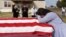 Lila Blanks reacts next to the casket of her husband, Gregory Blanks, 50, who died from complications from the coronavirus disease (COVID-19), ahead of his funeral in San Felipe, Texas, U.S., January 26, 2021. 