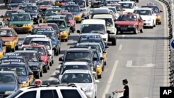 A lone Chinese cyclist faces traffic dominated by automobiles in Beijing, China (file photo)