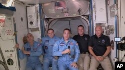 Los astronautas Bob Behnken and Doug Hurley durante una transmisión en vivo desde la Estación Espacial Internacional junto a la tripulación actual de la nave orbital el 31 de mayo de 2020. (Foto cortesía de la NASA)