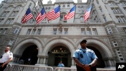 FILE - Law enforcement officers stand guard in front of the Trump Hotel in Washington, June 30, 2018.