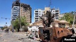 همزمان با تلاش ارتش سودان برای بازپس‌گیری مناطق تحت کنترل خود در خارطوم سودان اعضای ارتش در نزدیکی ساختمان‌های بمب‌گذاری شده راه می‌روند.