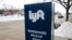 FILE - A sign for the car sharing service Lyft stands near a pickup zone outside the Pepsi Center in downtown Denver on Feb. 12, 2020.