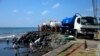 Trabajadores de la estatal Heritage Petroleum Oil and Gas Company limpian un derrame de petróleo que llegó a la playa de Rockly Bay, en Scarborough, suroeste de la isla de Tobago, Trinidad y Tobago, el 11 de febrero de 2024.