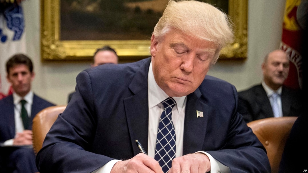 ARCHIVO - El presidente Donald Trump firma una orden ejecutiva en el Salón Roosevelt de la Casa Blanca en Washington, el 25 de abril de 2017.