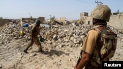 FILE - Pakistani soldiers stand near debris of a house which was destroyed during a military operation against Islamist militants in the town of Miranshah, North Waziristan, Pakistan, July 9, 2014. 